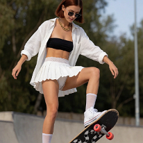 Perfect Balance: Skater Girl in White Pleated Skirt Owns the Arts District At a skate park in Los Angeles’ Arts District, a young woman balances her board in a perfect manual position. Her white linen shirt falls open over her black...